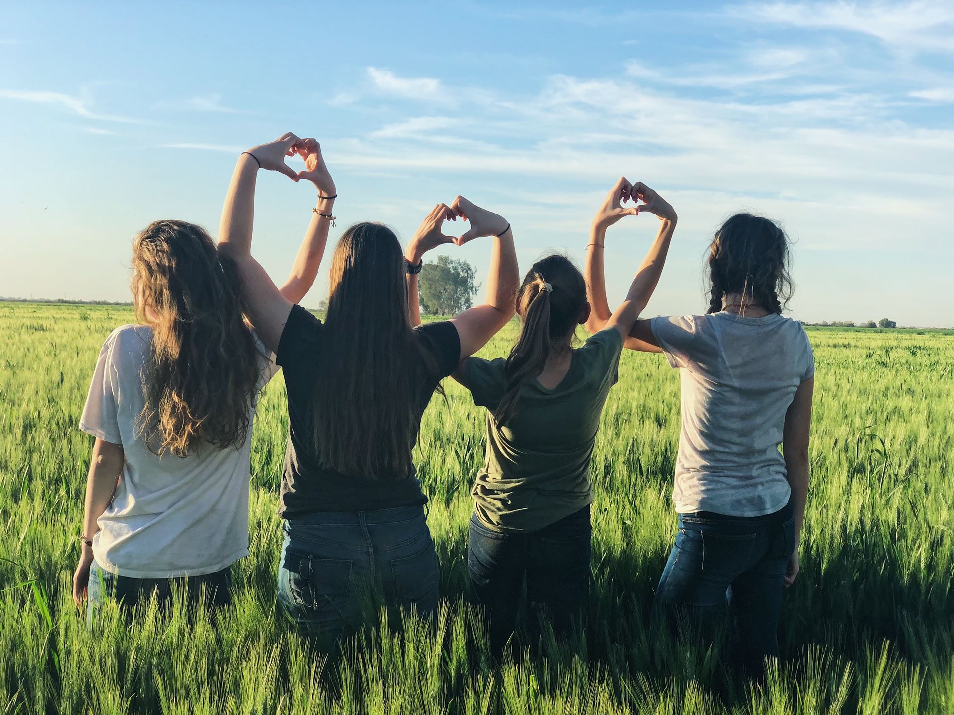 a group of people standing on top of a grass covered field